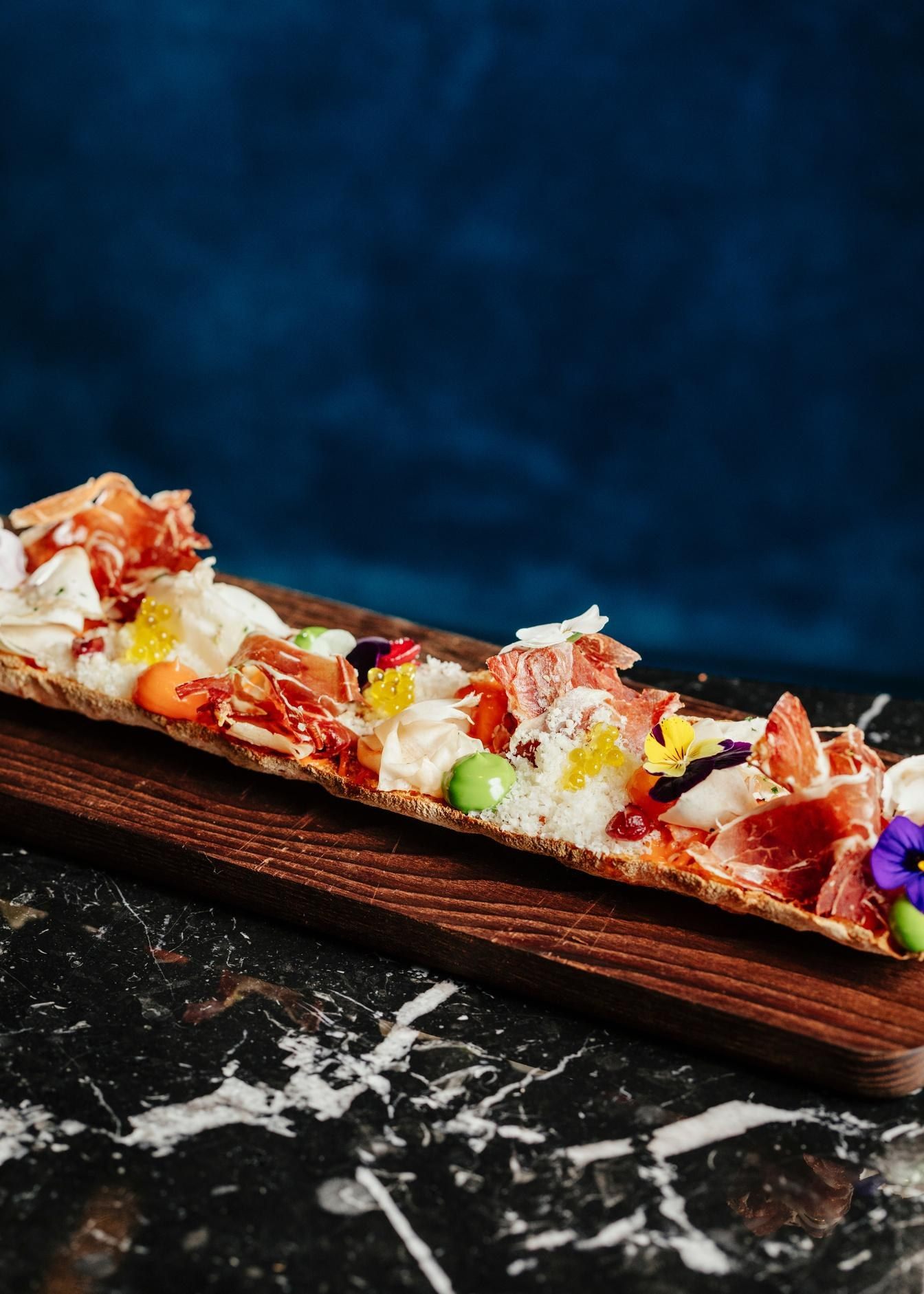 Ensalada y sushi sobre tabla de madera
