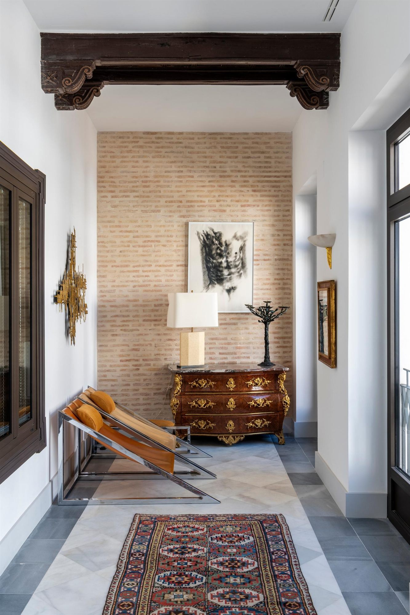 Pasillo interior con c&oacute;moda antigua y alfombra en el Hotel La Casa del Limonero