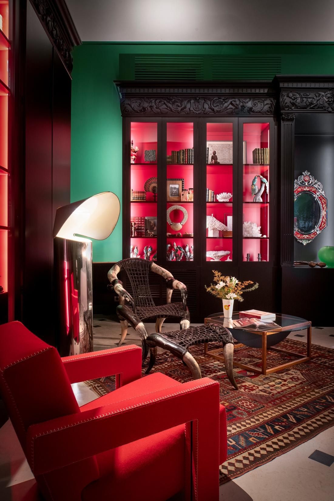 Sal&oacute;n biblioteca con butaca roja y paredes verdes