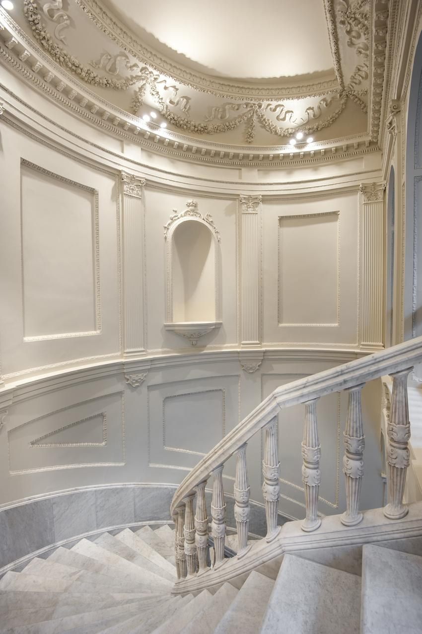 Escalera blanca con balaustrada curva