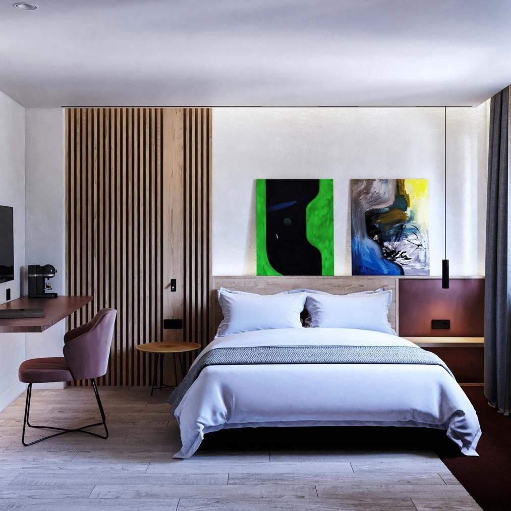 Habitaci&oacute;n del Hotel OLOM con cuadros contempor&aacute;neos sobre el cabecero