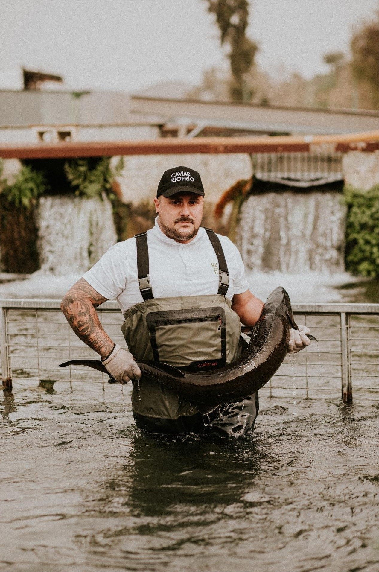 Pescador sosteniendo un esturi&oacute;n en las aguas de Riofr&iacute;o al amanecer