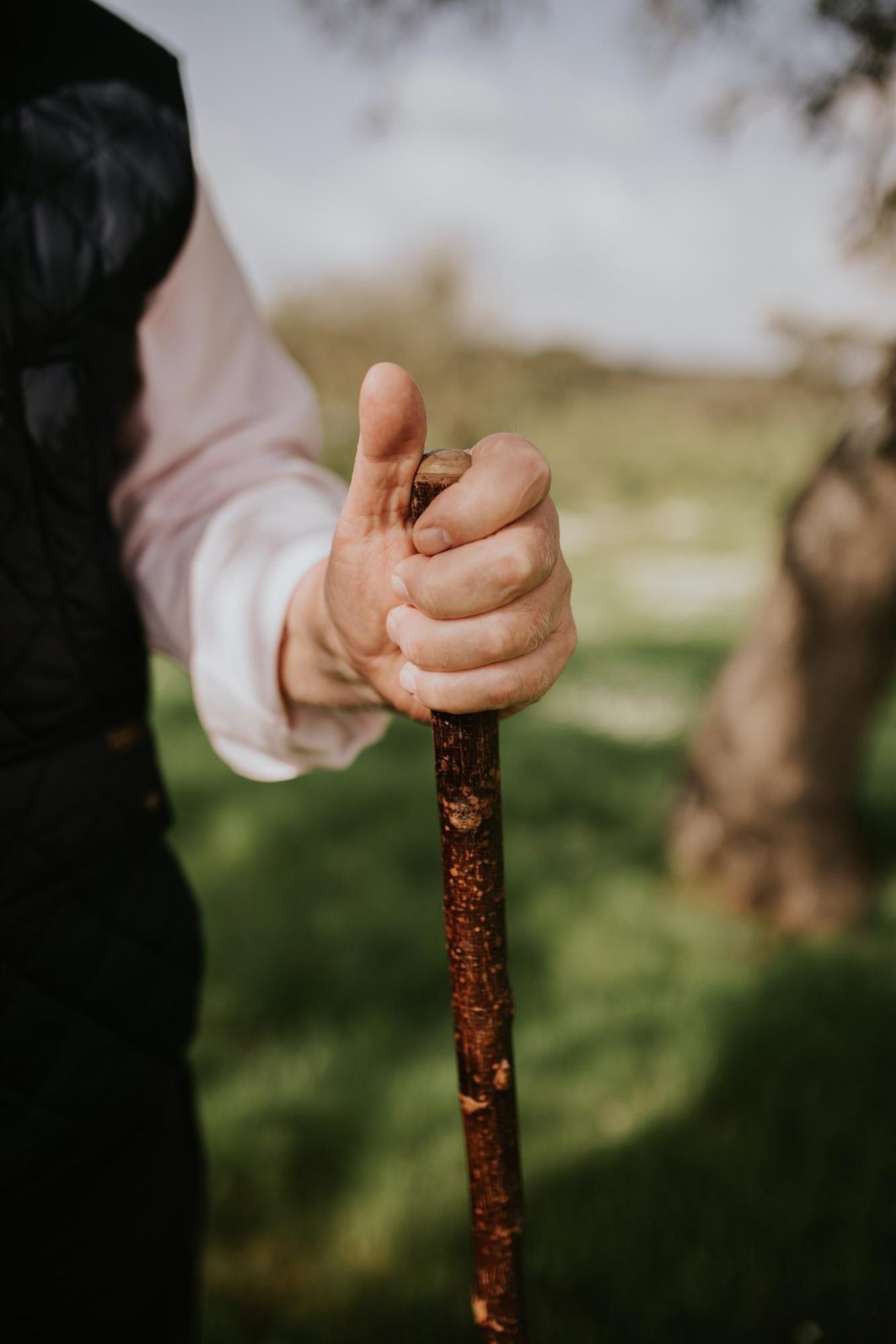 Mano apoyada sobre un palo de pastor en el campo andaluz