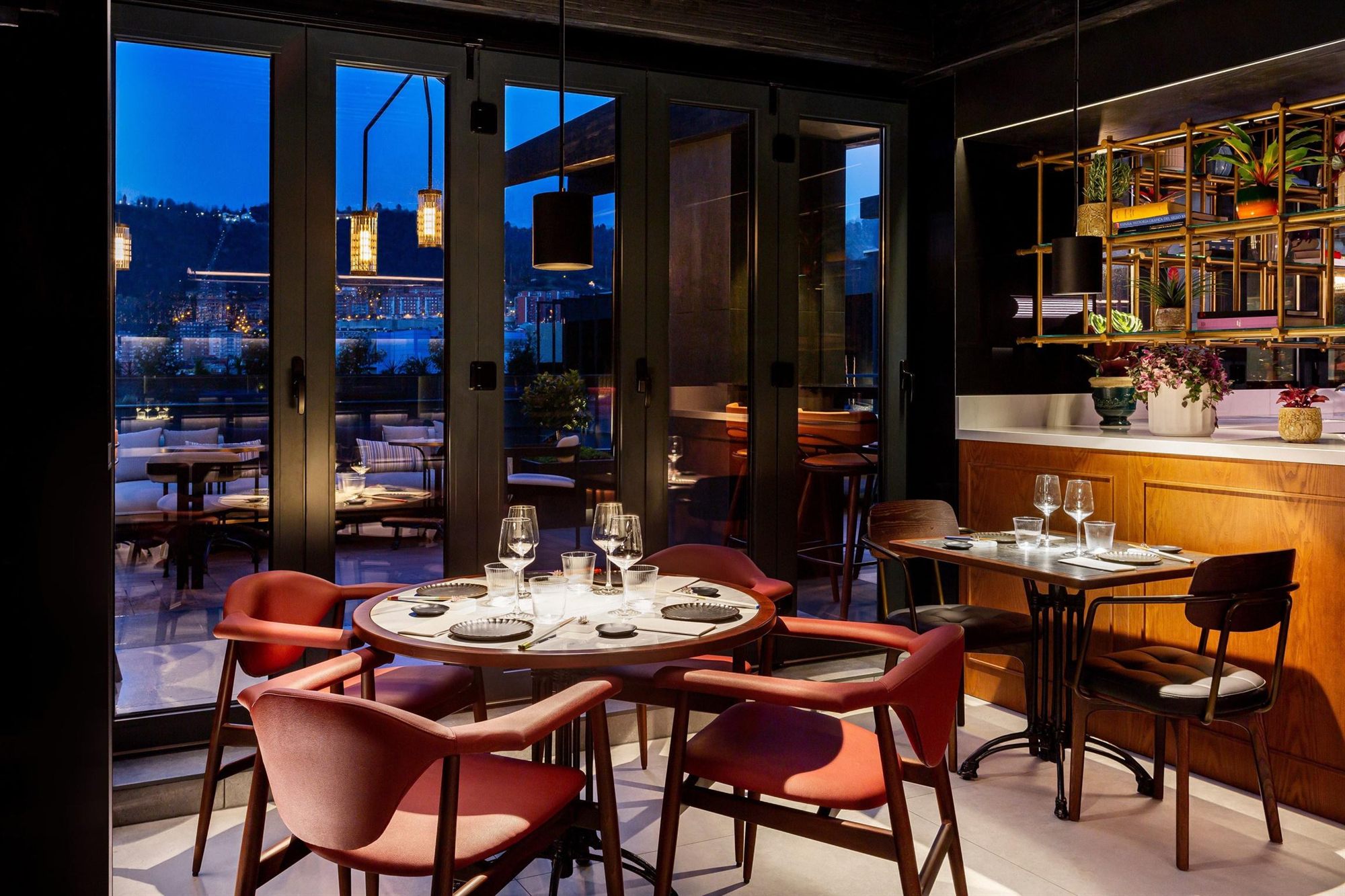 Comedor de NKO con vistas nocturnas de Bilbao