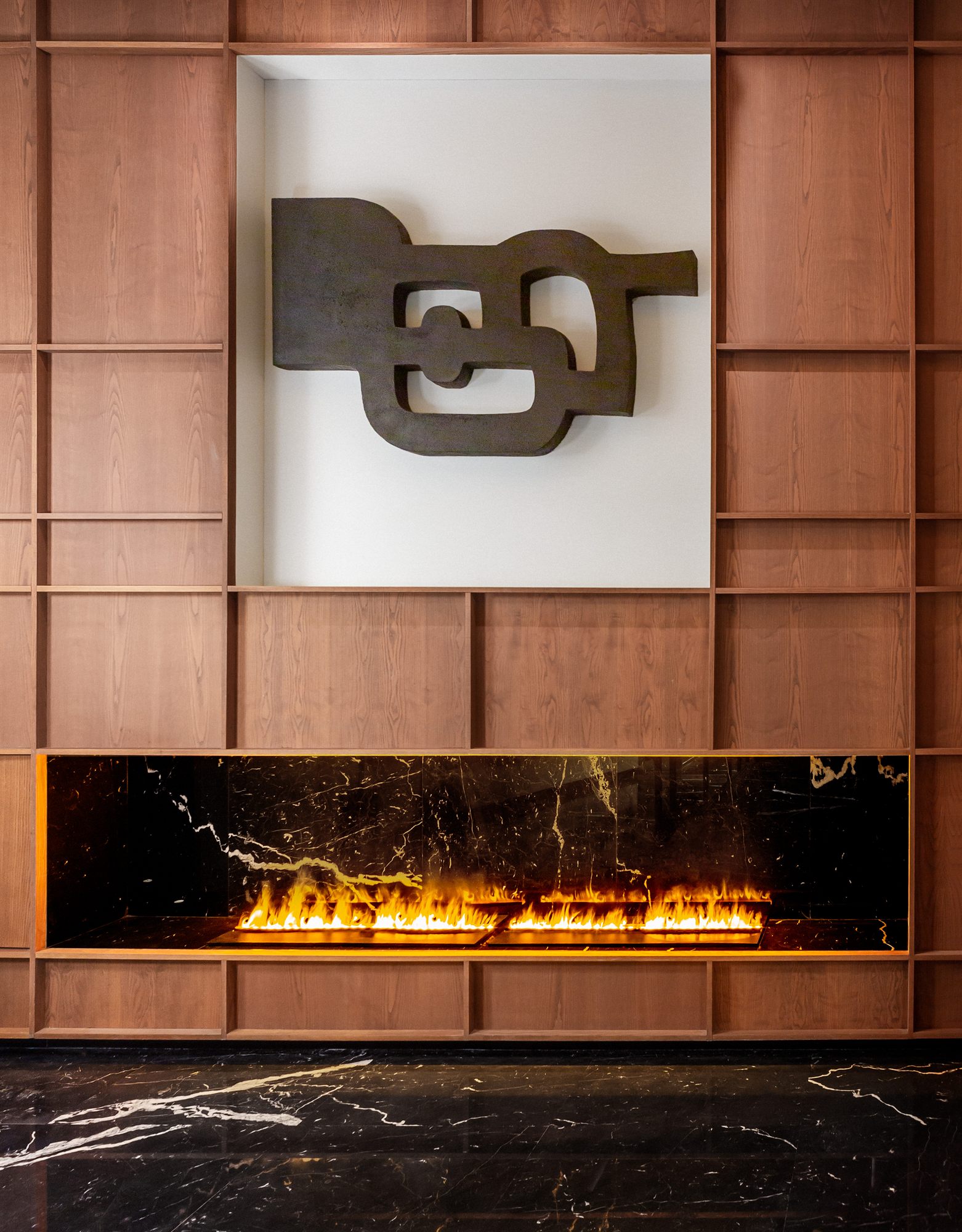 Chimenea con obra escultural sobre panelado de madera