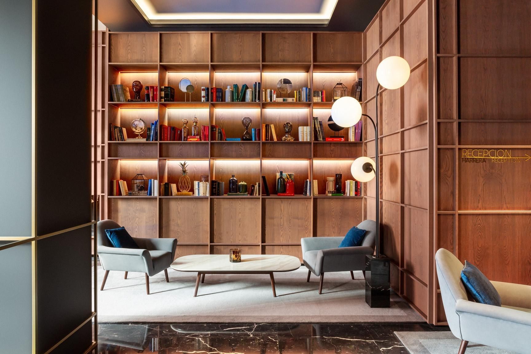 Biblioteca con sillones y estanter&iacute;a iluminada