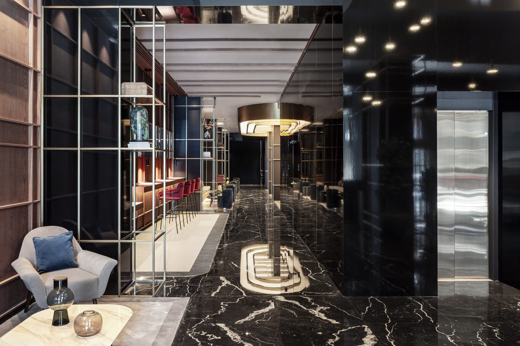Lobby de m&aacute;rmol negro con sill&oacute;n gris