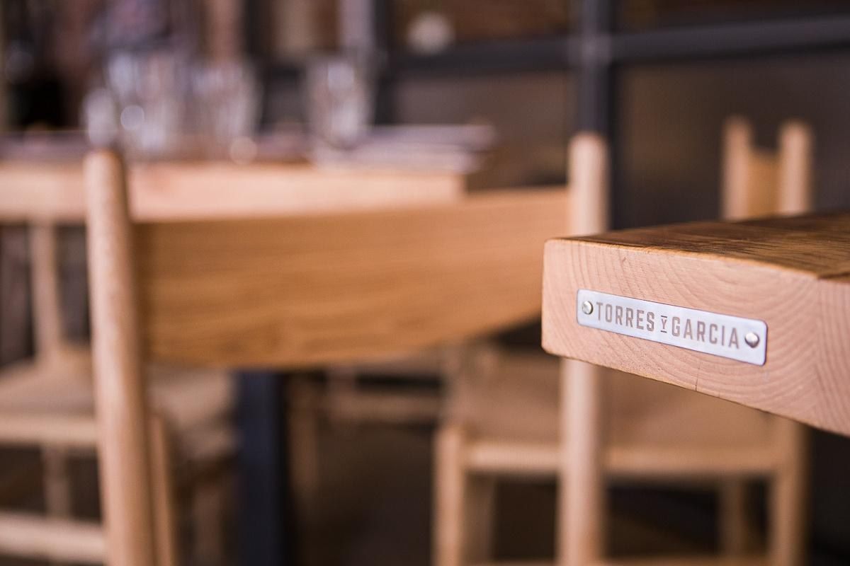Placa Torres y Garc&iacute;a en la mesa de madera